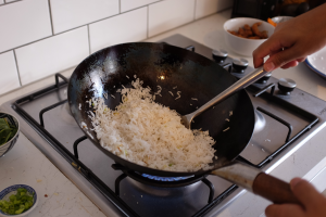 Image of rice being moved around and agitated in a wok