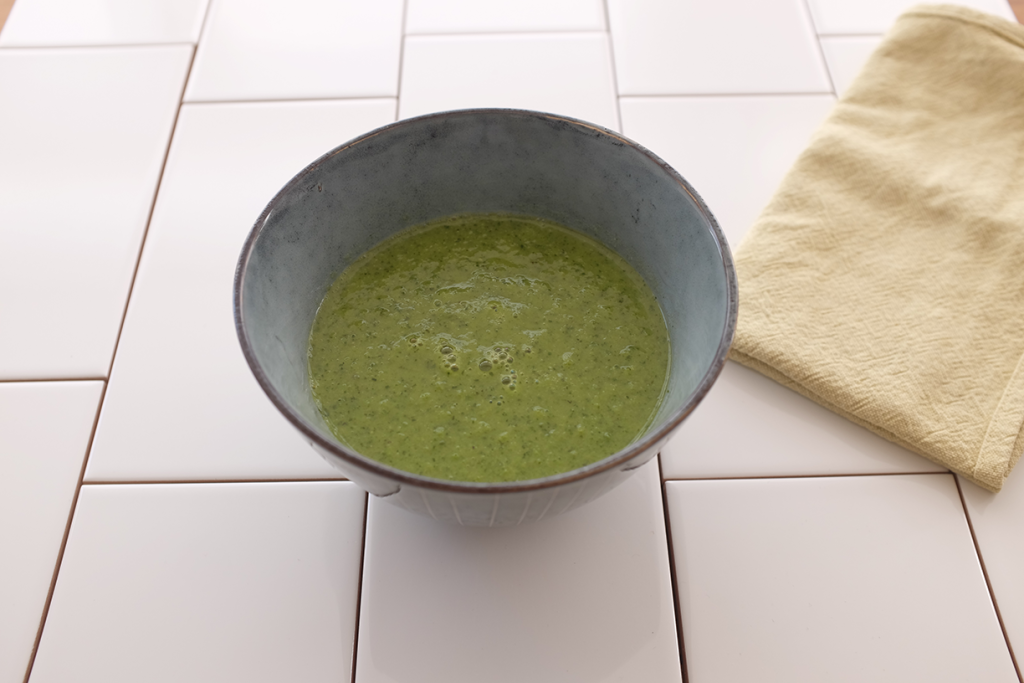 An image of a bowl of soup on a background of white tiles.