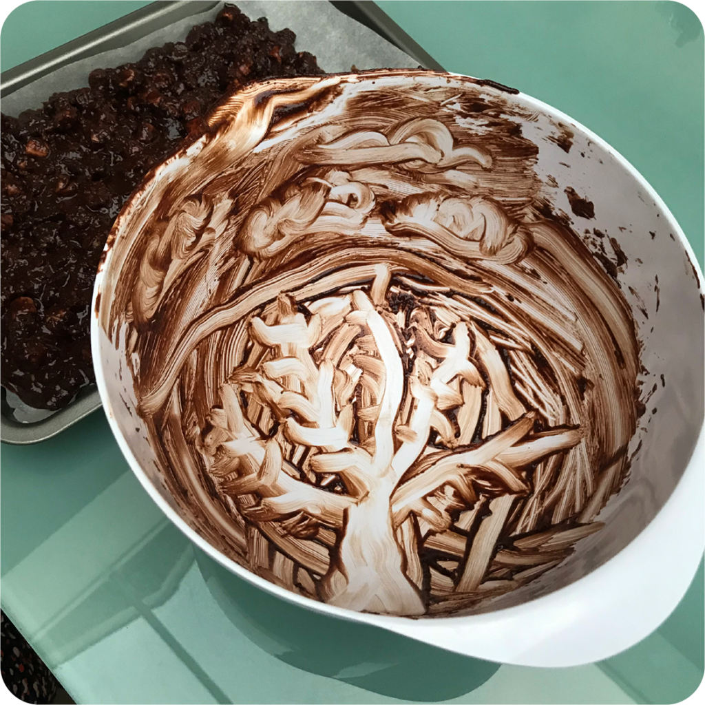 Leftover chocolate mix in a bowl with a Vincent Van Gough-style stree having been drawn into it using fingers. 