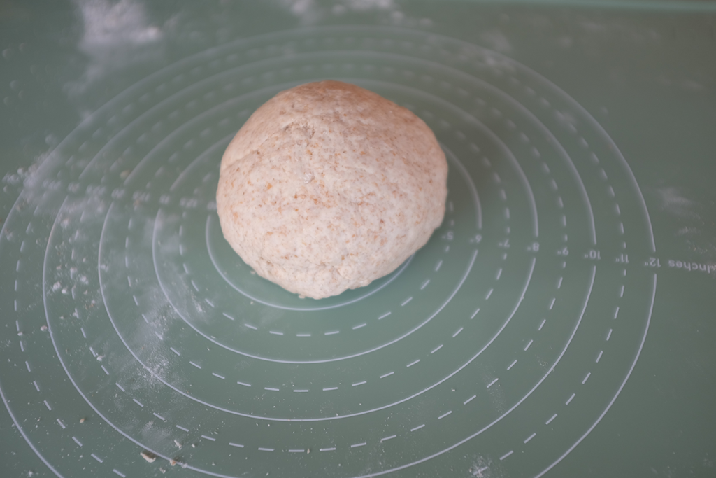 A ball of dough on a rolling mat.