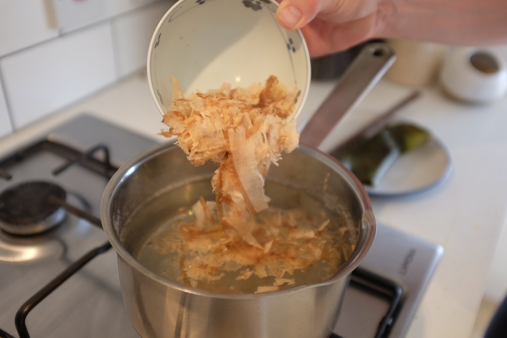 Katsuobushi flakes being added to dashi.