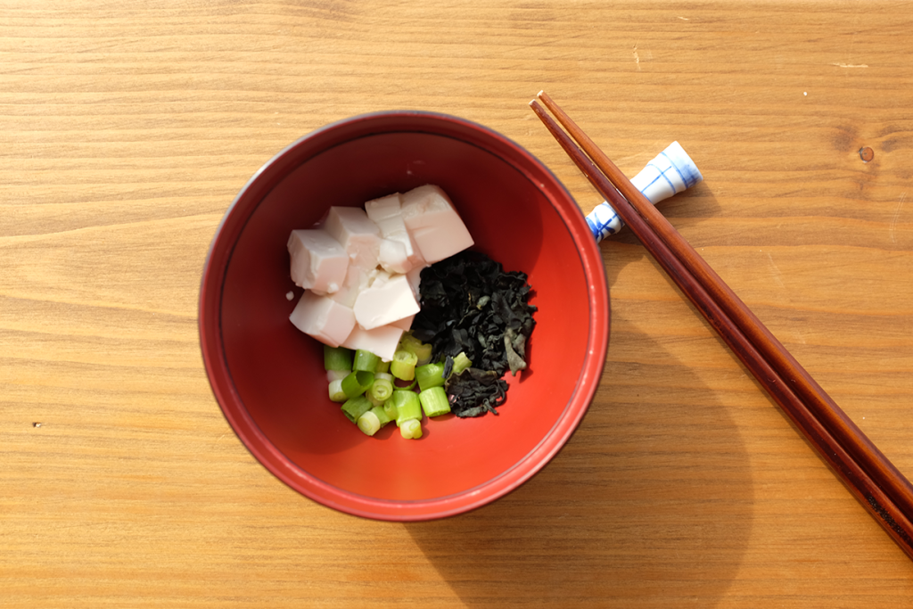 Tofu, spring onions and wakame in a bowl.