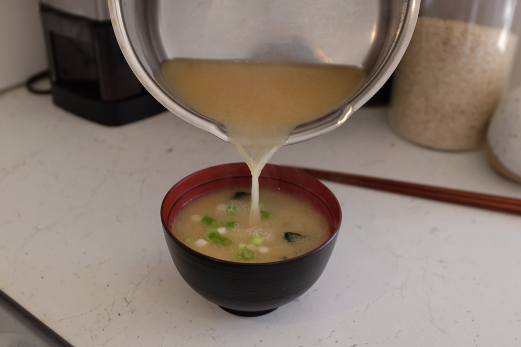 Pouring miso soup into a bowl.