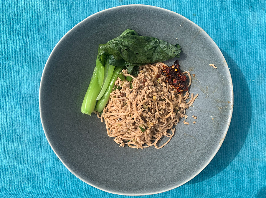 Noodles in a bowl with steamed pak choi.