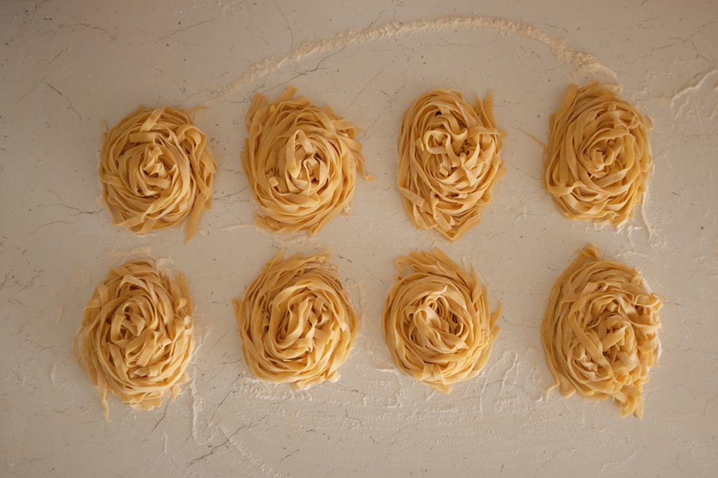 Eight nests of tagliatelle pasta.