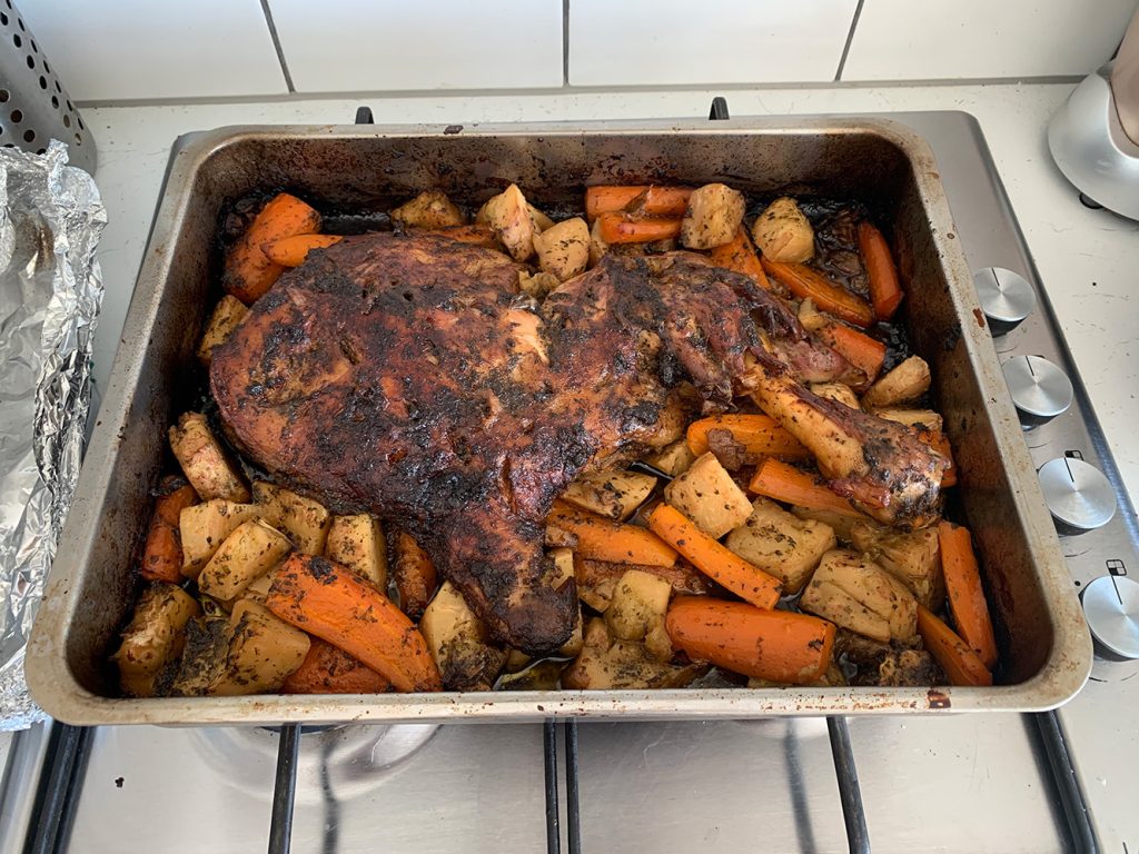Image of lamb and vegetables roasted in a pan.